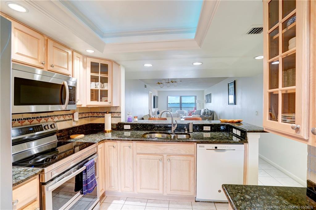10 Northeast Plantation Road, Unit 101 Jensen Beach, FL 34957 - Photo 8 of 53 a kitchen with stainless steel appliances a stove a sink and a microwave