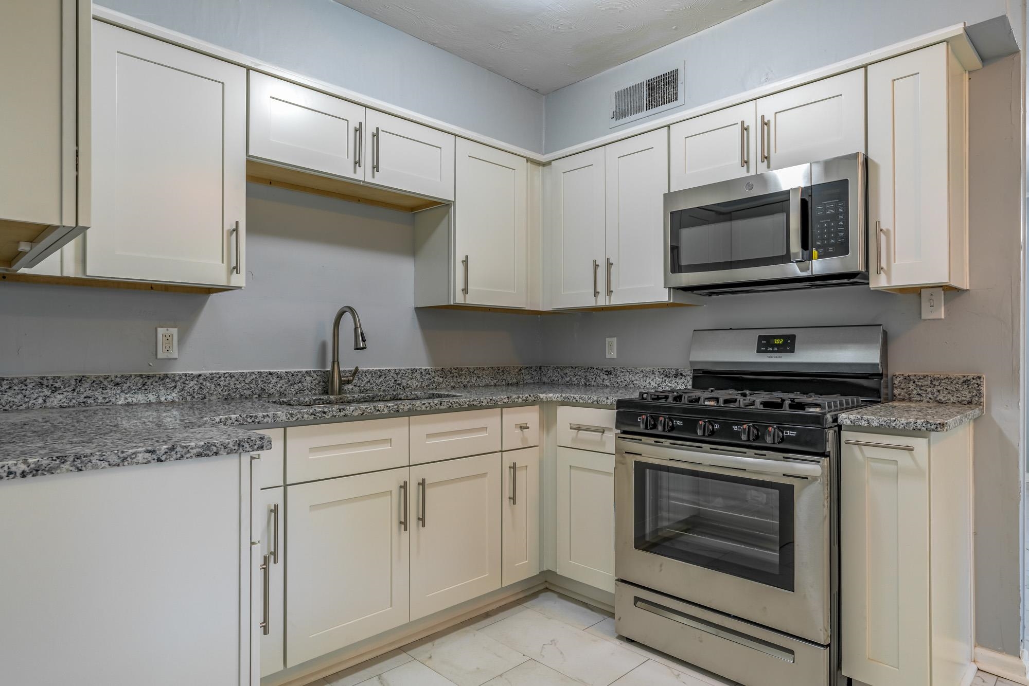 4606 Tulane Road Memphis, TN 38109 - Photo 13 of 25 a kitchen with stainless steel appliances granite countertop white cabinets a sink and dishwasher