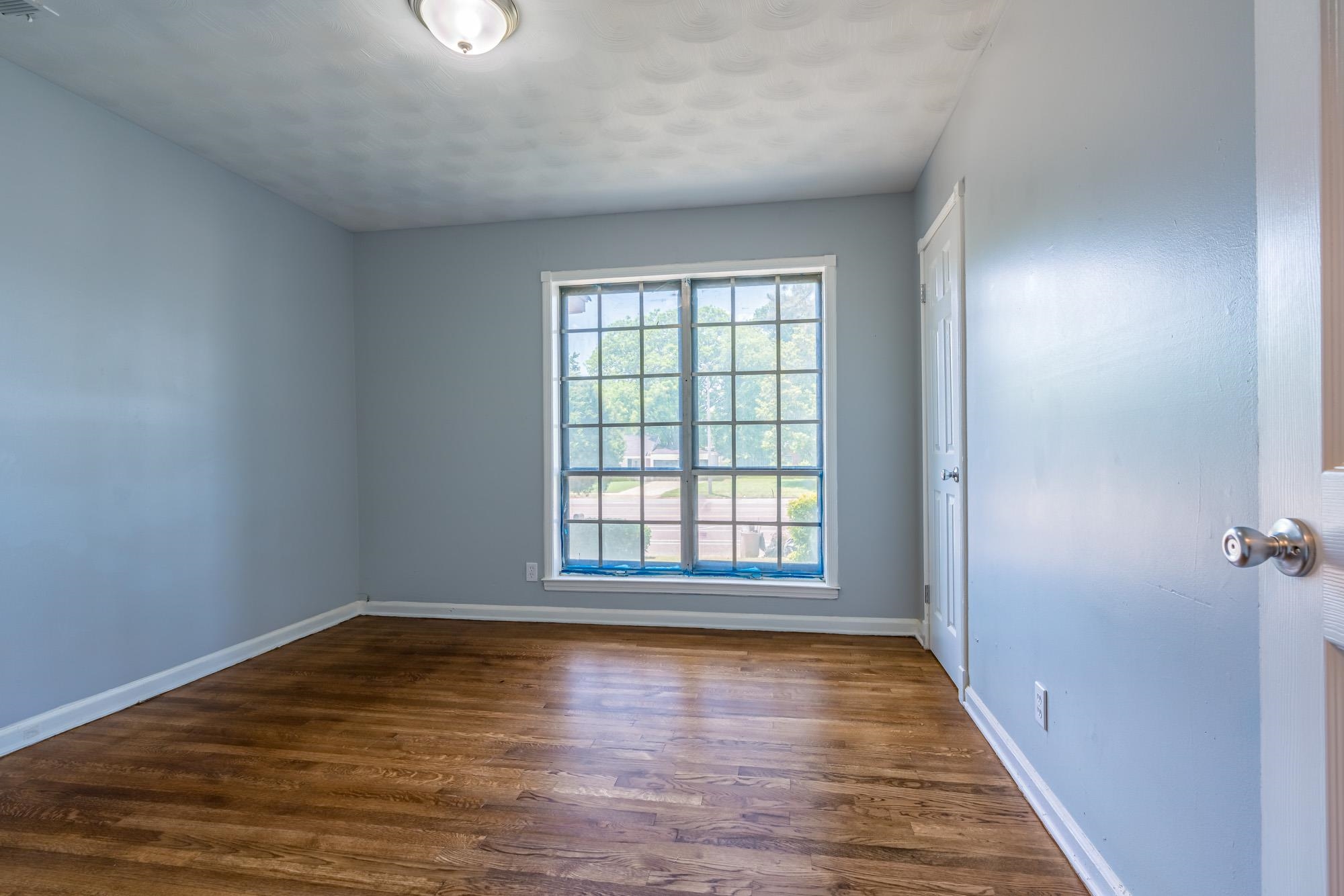 4606 Tulane Road Memphis, TN 38109 - Photo 21 of 25 a view of an empty room with wooden floor and a window