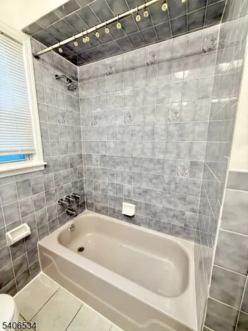 a bathroom with a white bath tub and a shower