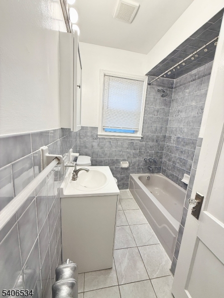 727 Pennington Street Elizabeth, NJ 07202 - Photo 10 of 18 a bathroom with a double vanity sink a bathtub and a shower