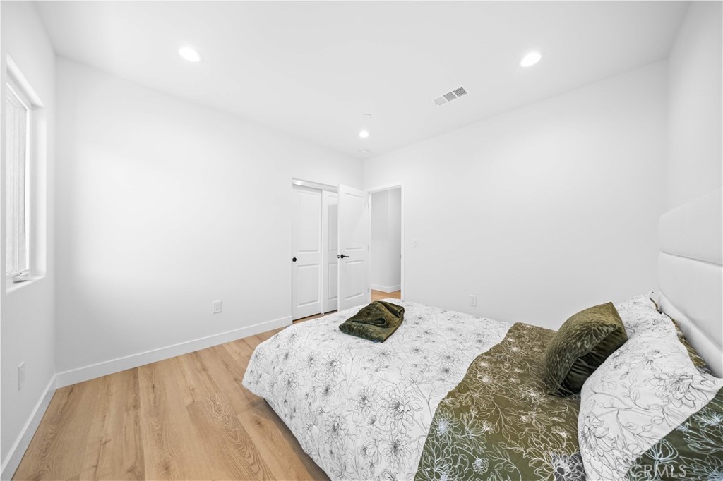 7692 9th Street, Unit 113 Buena Park, CA 90621 - Photo 25 of 41 a bedroom with a bed and a wooden floor