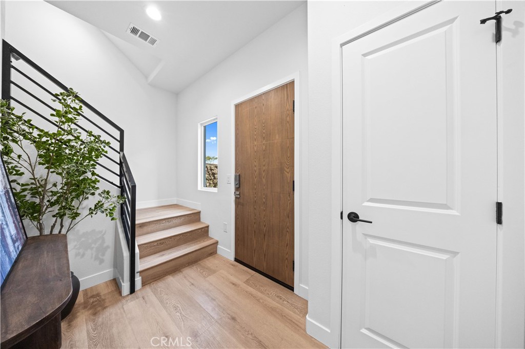 7692 9th Street, Unit 113 Buena Park, CA 90621 - Photo 4 of 41 a view of front door with wooden floor and stairs