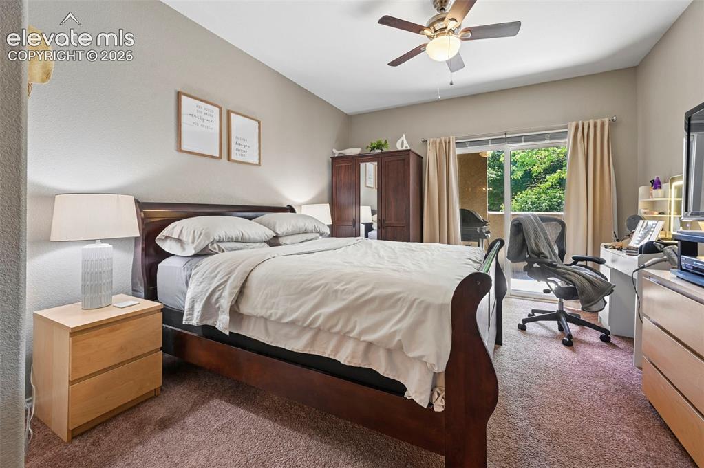 3715 Riviera Grove, Unit 101 Colorado Springs, CO 80922 - Photo 24 of 36 Bedroom featuring textured carpeting, a ceiling fan with light fixture, and direct access to an outdoor balcony through sliding glass doors