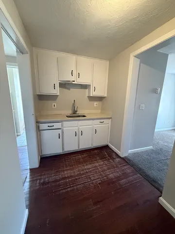 a kitchen with cabinets stove and sink