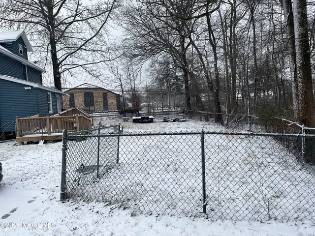a view of backyard with barbeque grill and wooden fence