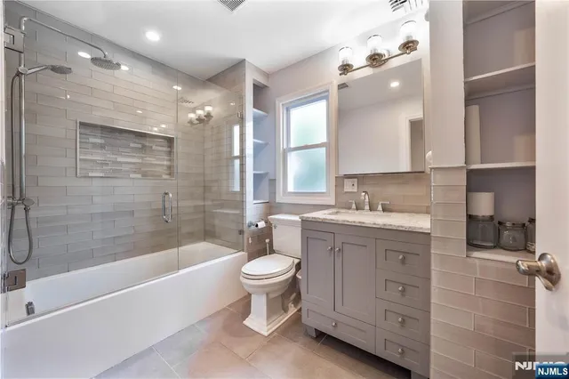 a bathroom with a double vanity sink toilet and shower