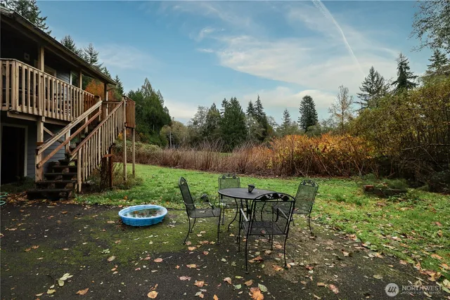 a view of backyard with table and chairs