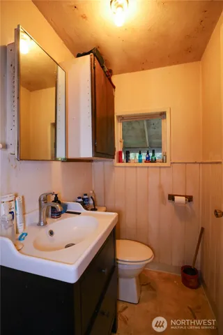 a bathroom with a sink a toilet and mirror
