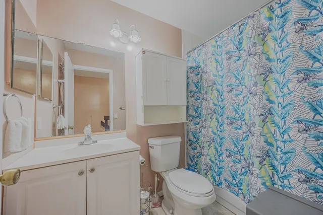 a bathroom with a granite countertop sink a toilet and a mirror