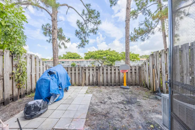 a view of a yard with wooden fence