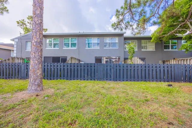 a view of a house with a yard and wooden fence