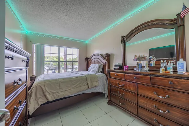 a bedroom with a bed and a mirror on dresser