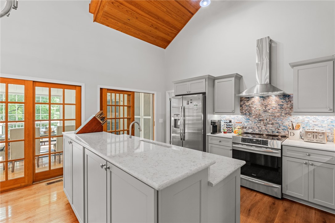 300 Whispering Falls Road Pickens, SC 29671 - Photo 10 of 41 Vaulted wood-paneled ceilings and stone countertops define this kitchen space with hardwood flooring.