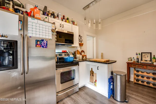 a kitchen with granite countertop a sink a stove and cabinets