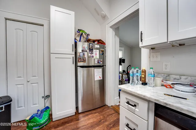 a bedroom with furniture a flat screen tv and a window