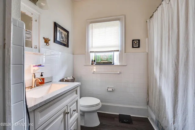a bathroom with a sink a toilet and a window