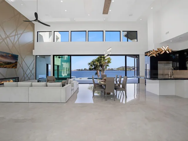 a living room with furniture a chandelier and a floor to ceiling window