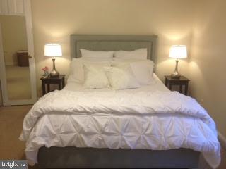 24 South Old Glebe Road, Unit 202 Arlington, VA 22204 - Photo 20 of 22 a large bed sitting in a bedroom next to a lamp