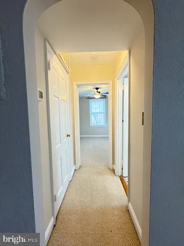 view of a hallway with wooden shelves