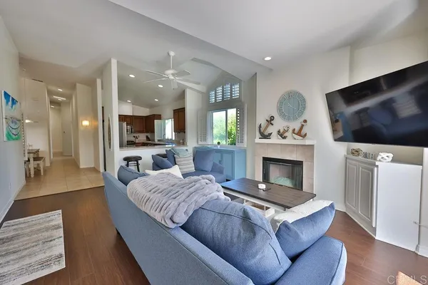 a living room with furniture a flat screen tv and a fireplace