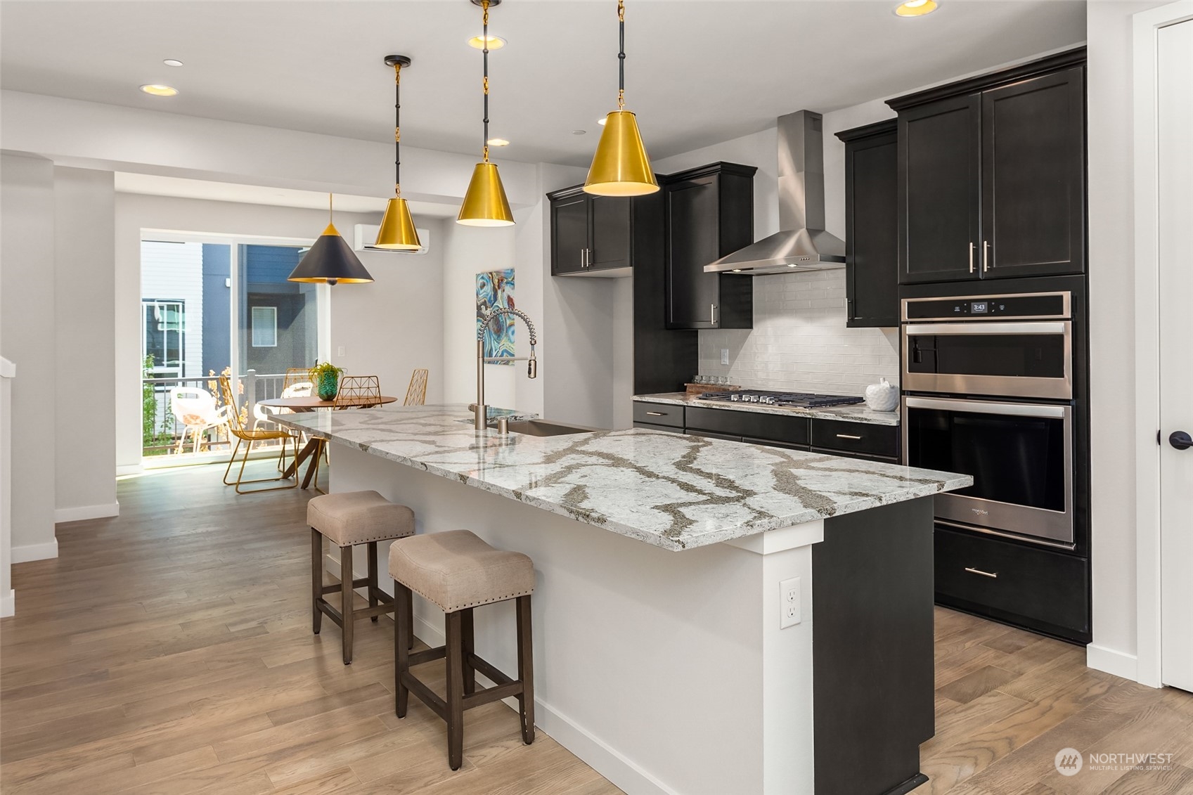 616 237th Place Southeast, Unit E Bothell, WA 98021 - Photo 6 of 27 a kitchen with kitchen island a stove a table and chairs in it