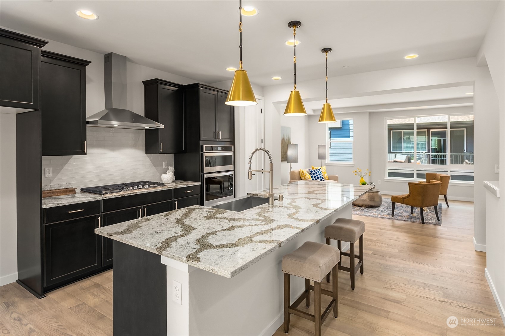 616 237th Place Southeast, Unit E Bothell, WA 98021 - Photo 7 of 27 a kitchen with stainless steel appliances kitchen island granite countertop a stove a refrigerator a kitchen island a patio and a dining table