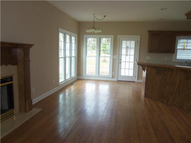 1250 Carter Blake Road Tullahoma, TN 37388 - Photo 14 of 20 The den area is located in back of home, is open to the kitchen and breakfast area. Featuring wood floors & gas log fireplace & access to back porch area. Enjoy the views of the beautiful acreage & pond in back..
