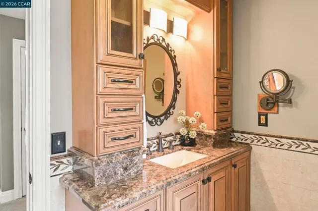 a bathroom with a granite countertop sink and a mirror