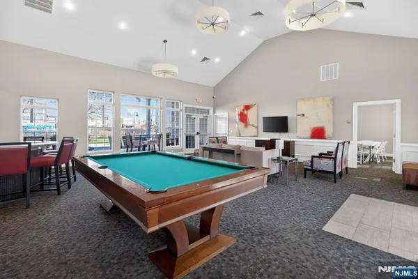 a room with pool table and windows