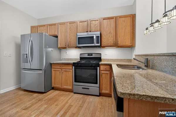 a kitchen with granite countertop a refrigerator stove and microwave