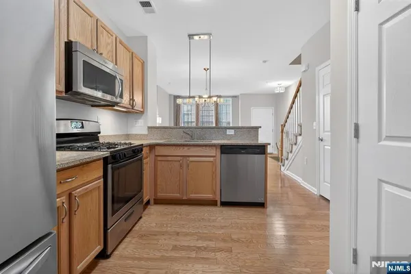 a kitchen with stainless steel appliances granite countertop a stove a sink and a microwave