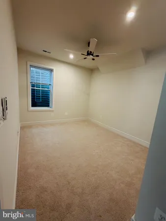 an empty room with a window and a ceiling fan