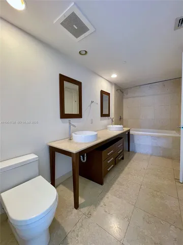 a spacious bathroom with a toilet sink and mirror