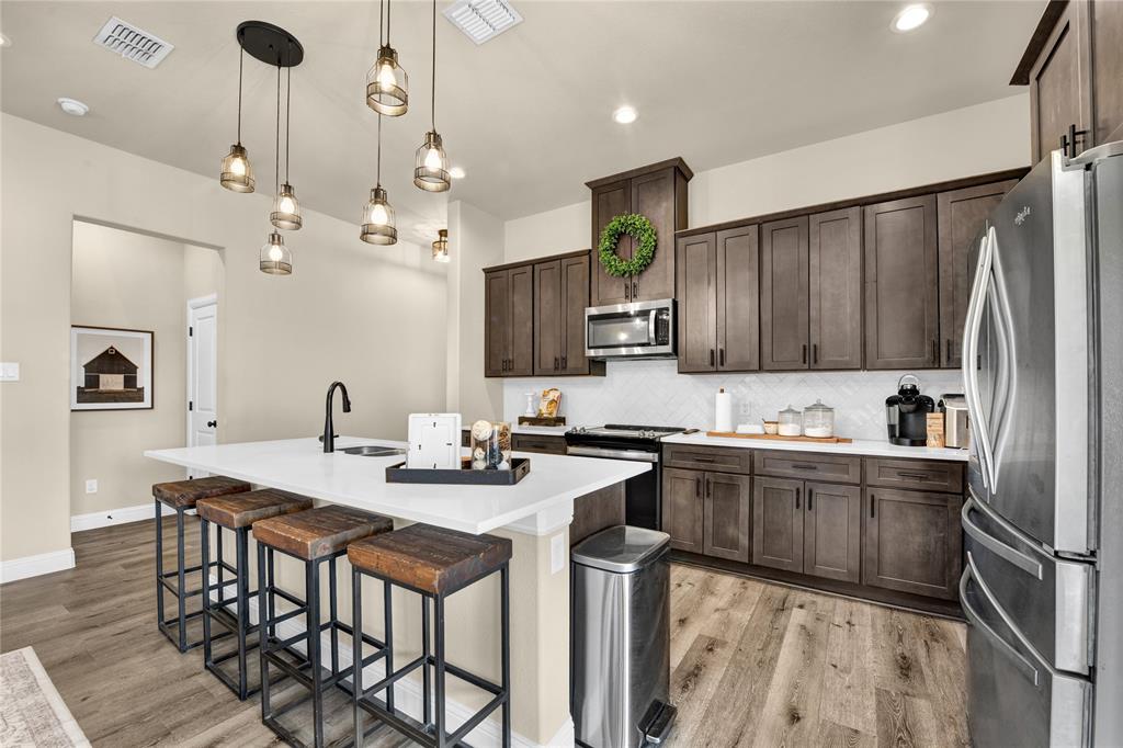 2044 Redemption Drive Weatherford, TX 76088 - Photo 23 of 30 a kitchen with granite countertop a sink appliances and cabinets