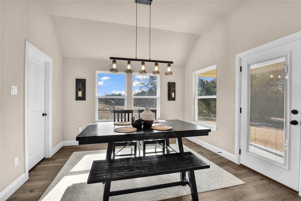 2044 Redemption Drive Weatherford, TX 76088 - Photo 27 of 30 a dining room with wooden floor a chandelier a wooden table and chairs