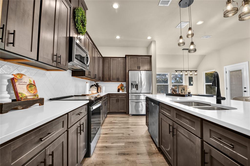 2044 Redemption Drive Weatherford, TX 76088 - Photo 28 of 30 a kitchen with stainless steel appliances granite countertop a sink a stove and a refrigerator