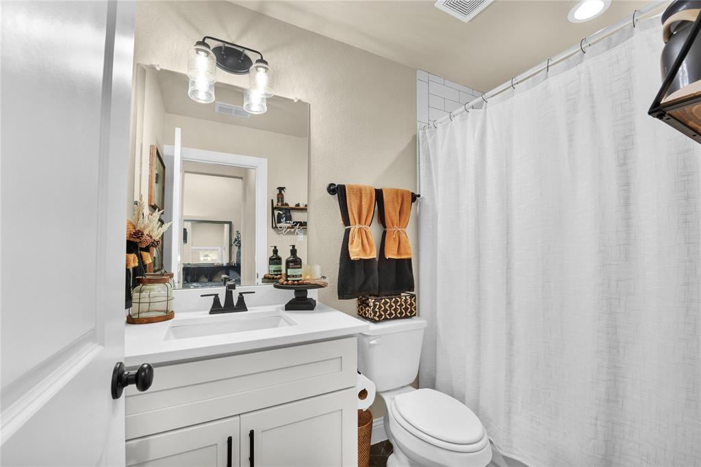 2044 Redemption Drive Weatherford, TX 76088 - Photo 10 of 30 a bathroom with a sink a toilet a mirror and shower curtain