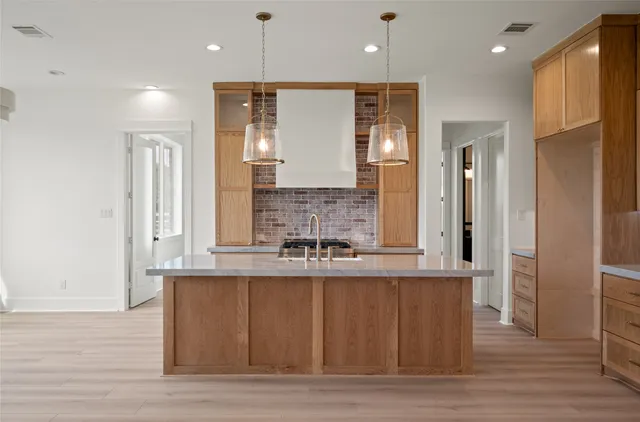 a large kitchen with granite countertop a large window and stainless steel appliances