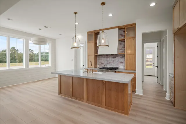 a large kitchen with stainless steel appliances a large counter top a sink and a refrigerator