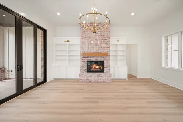 a view of empty room with floor to ceiling window and fireplace