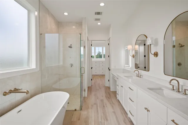 a bathroom with a double vanity sink a toilet a mirror and shower