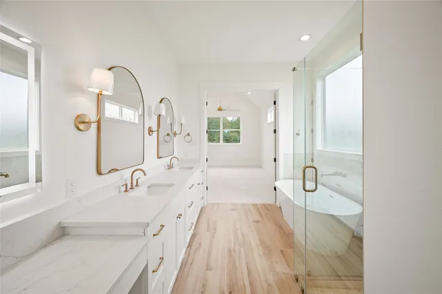 a spacious bathroom with a tub sink and mirror