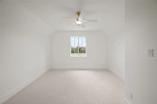 an empty room with window and ceiling fan