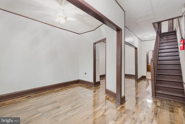 a view of a hallway with wooden floor and staircase