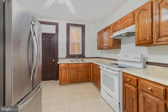 a kitchen with stainless steel appliances granite countertop a refrigerator and a sink