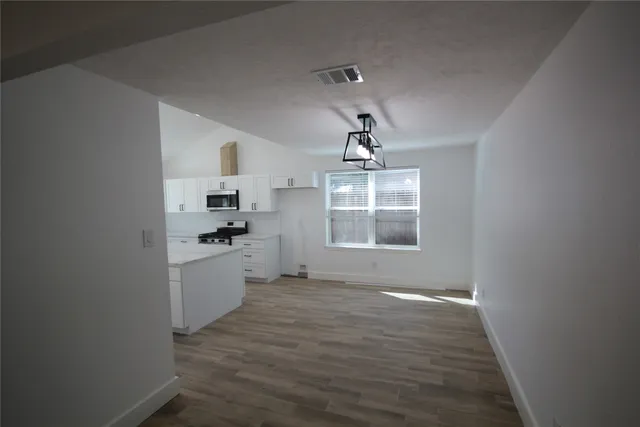 a kitchen with granite countertop a sink cabinets a window and stainless steel appliances