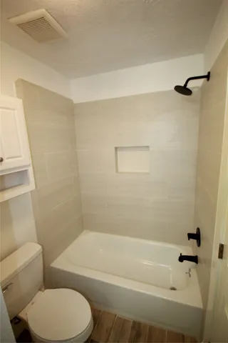 a bathroom with a toilet and a bath tub