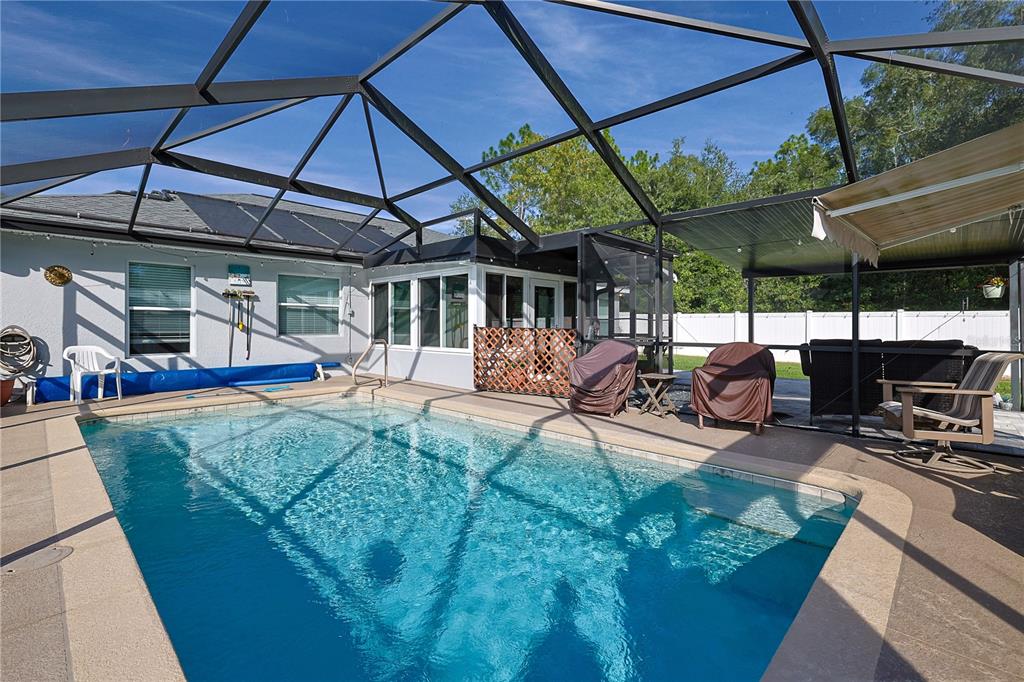 6367 Southwest 117th St Road Ocala, FL 34476 - Photo 33 of 43 a view of a backyard with table and chairs under an umbrella