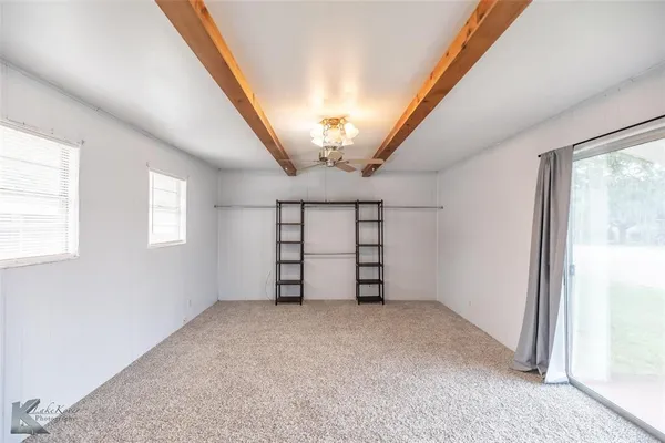 a view of a room with a windows and ceiling fan